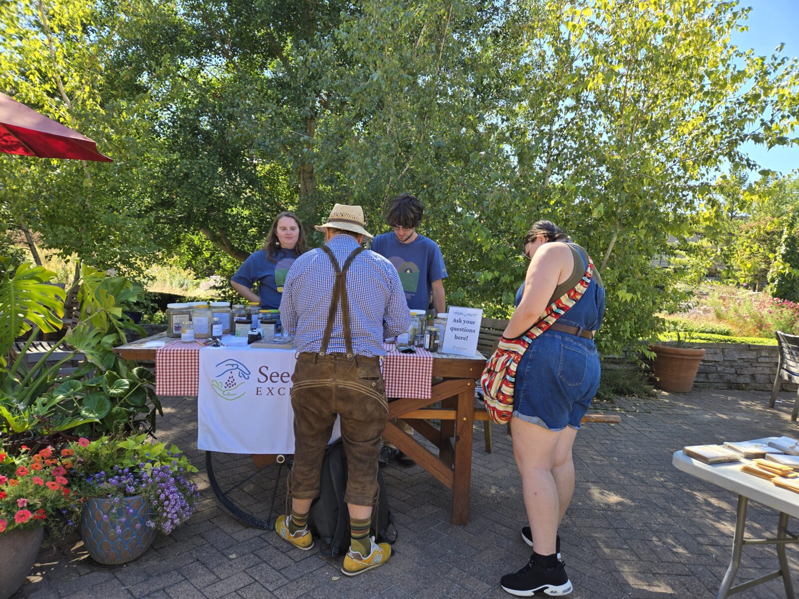 People gathered around a wooden cart with seeds on top